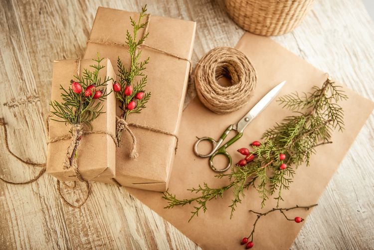 Vianočné darčeky zabalené do obyčajného papiera a ozdobené halúzkami šípky