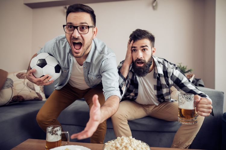 Kamaráti sledujúci športový zápas v TV