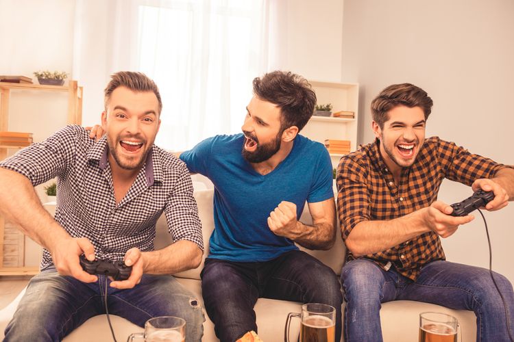Muži hrajúci hry na televízore a pijúci pivo