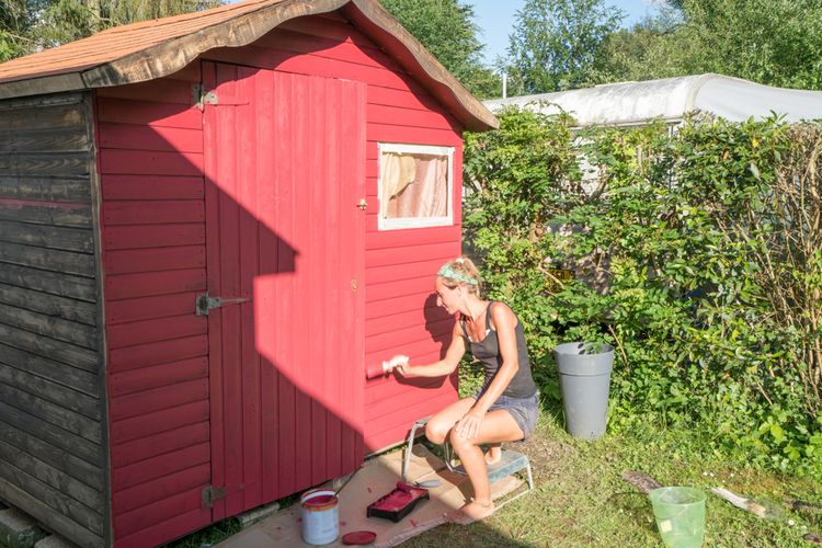 Maľovanie záhradného domčeka červenou farbou