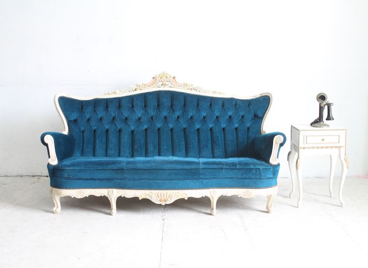 Modrá zamatová pohovka v retro obývačke