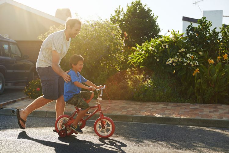 Otec učiaci syna jazdiť na bicykli