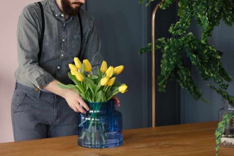 Žlté tulipány v modrej sklenenej váze