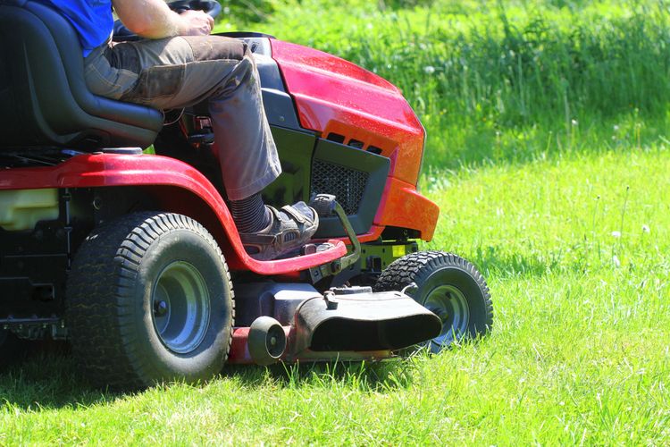 Červený záhradný traktor na kosenie trávy