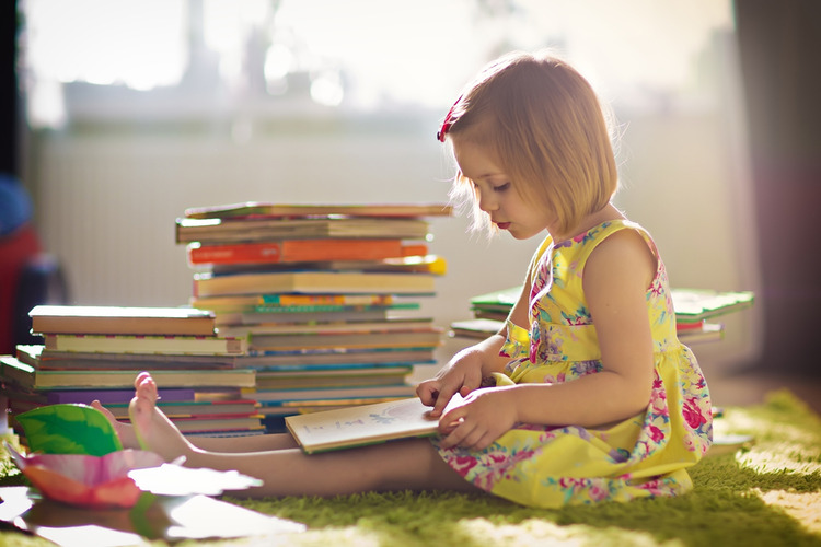 Malé dievčatko číta knihy pre deti